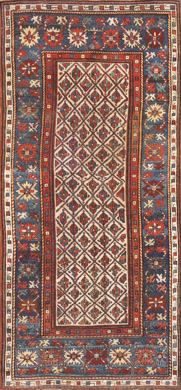 Geometric pattern rug in indigo, rust red, and cream featuring a central diamond lattice design.