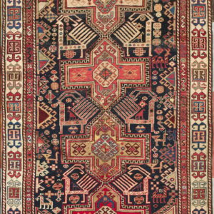 Low pile rug featuring a complex geometric pattern with a navy field and borders of red, beige, and gold.
