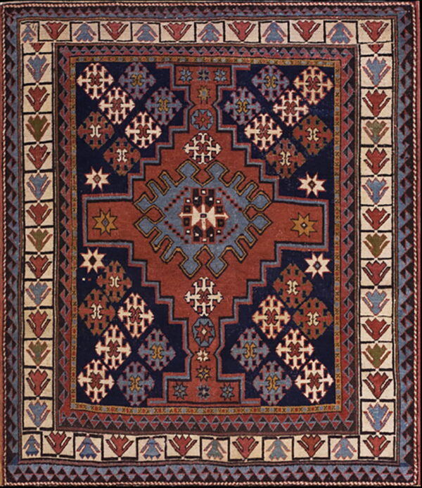 Stepped medallion rug in navy blue, rust red, and slate blue with complex geometric patterns.