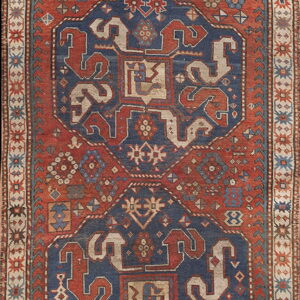 Geometric runner rug in rust and indigo colors with three linked central octagonal medallions.