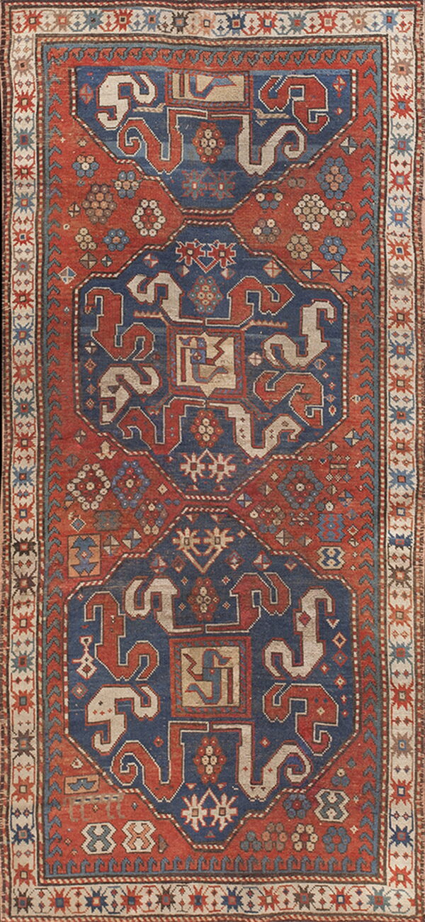 Geometric runner rug in rust and indigo colors with three linked central octagonal medallions.