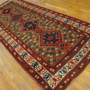 Traditional runner with repeating red and blue diamonds on a dense brown field over wood flooring.