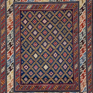 Geometric rug featuring a blue field with repeating yellow and red diamonds and complex multicolored borders.