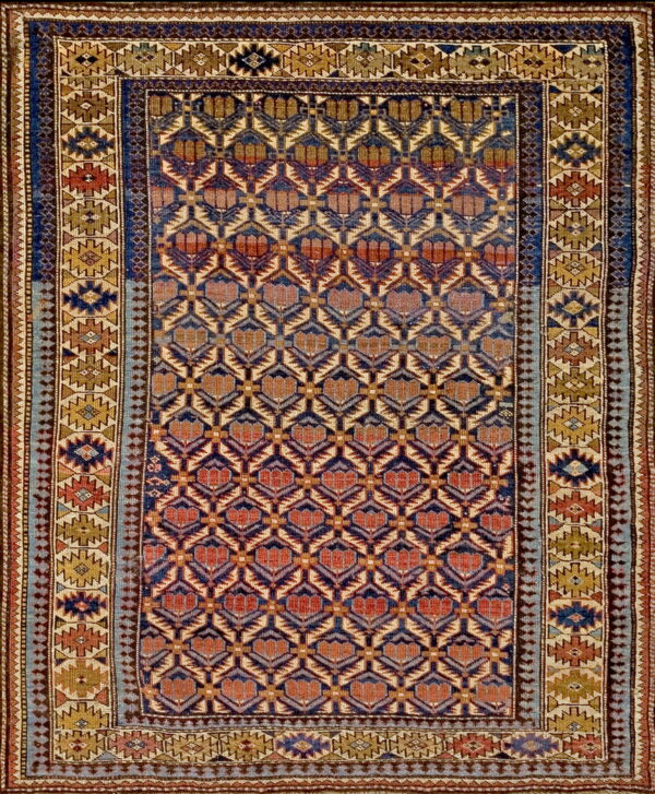 Geometric rug featuring a deep blue and rust repeating motif field with intricate gold and blue striped borders.
