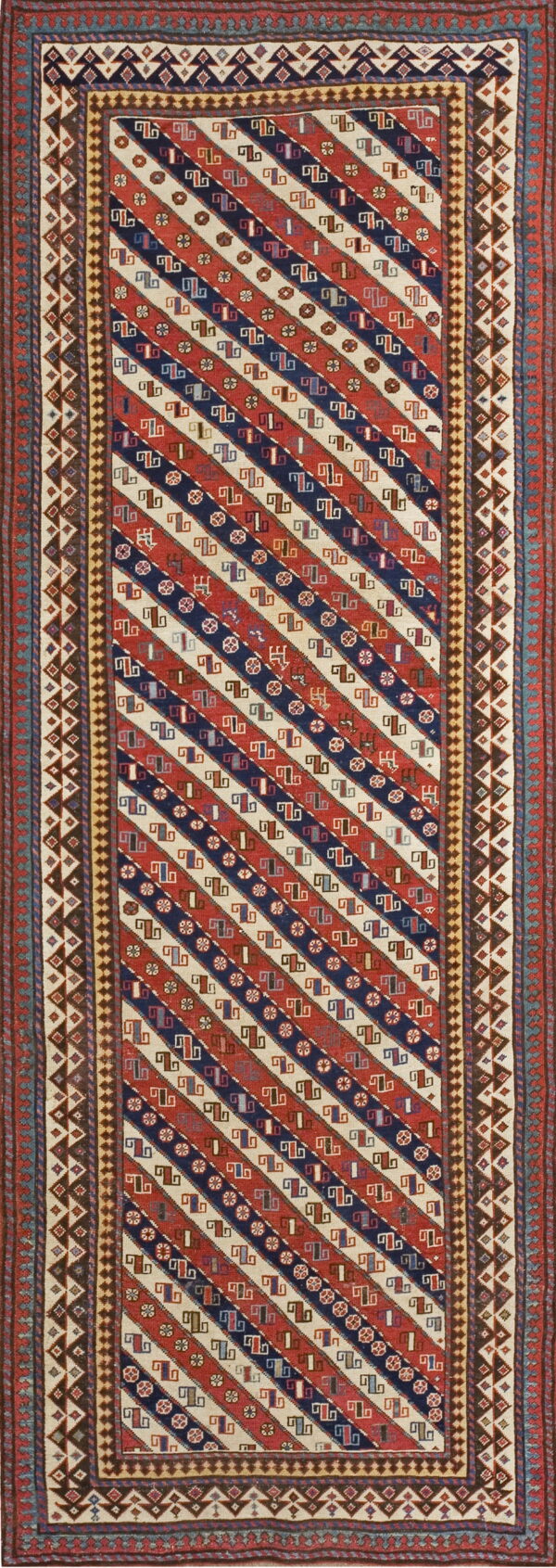 Runner rug featuring geometric diagonal stripes in red, navy, and cream with elaborate multi-layered borders.