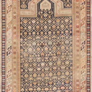 Geometric rug with a navy and tan diamond pattern field and a stepped arch design at the top.