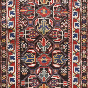 Traditional runner rug with a black field, complex repeating geometric patterns in red, blue, and white.