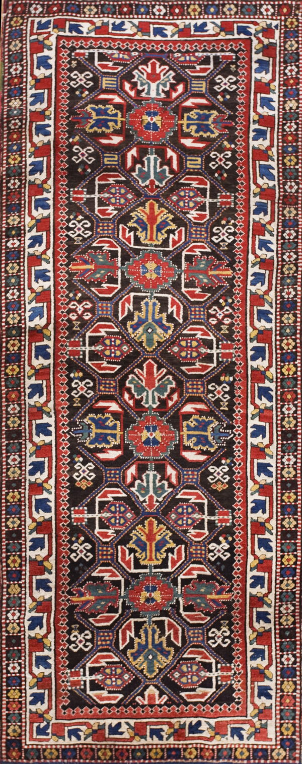 Traditional runner rug with a black field, complex repeating geometric patterns in red, blue, and white.