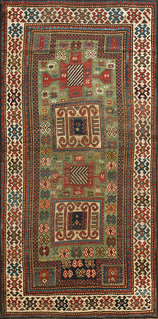 Geometric rug with a muted green field, complex red and blue tribal medallions, and wide patterned borders.