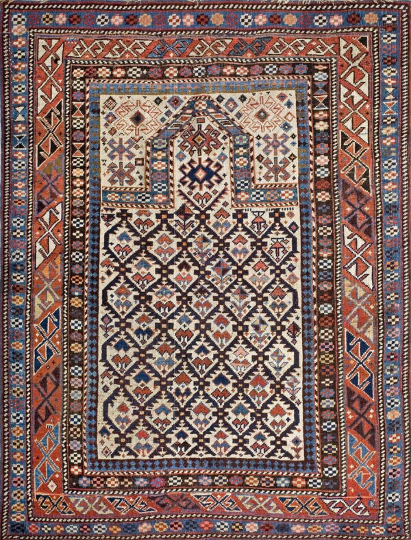 Densely patterned rug featuring multiple geometric borders, rust edges, and a cream field with navy lattice.
