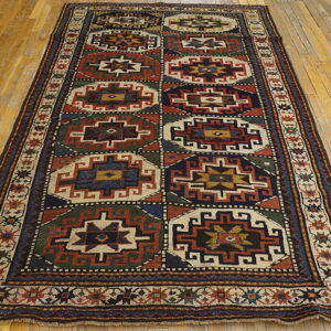 Runner rug featuring geometric blocks in red, navy, green, and cream on golden wood floors.
