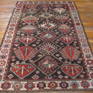 Runner rug with a dark field and contrasting red, blue, and cream tribal geometric motifs on hardwood.
