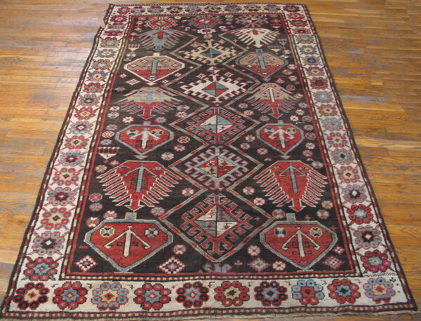 Runner rug with a dark field and contrasting red, blue, and cream tribal geometric motifs on hardwood.