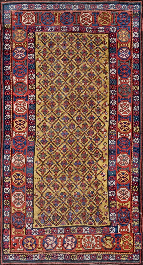 Gold rug with a repeating diamond lattice pattern and bold red, blue, and white geometric medallion borders.