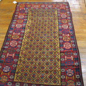 A long, low-pile red, gold, and blue geometric rug rests upon light brown hardwood floors.