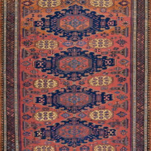 Rust and navy geometric runner rug with three large repeating central medallions and complex patterned borders.