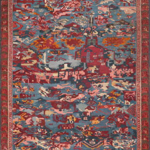Low-pile rug featuring dense, abstract motifs in blue, red, dusty pink, and orange with a wide patterned border.