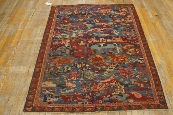 Low-pile runner rug with complex blue, red, and earth-toned abstract designs over yellow hardwood.