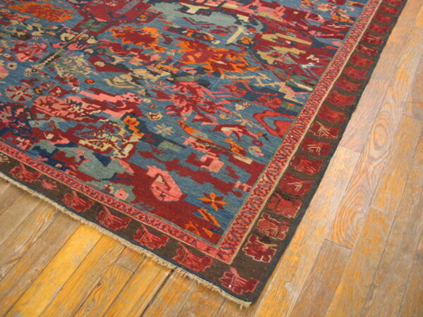 A colorful geometric rug with blue and deep red abstract patterns rests on light wood plank flooring.