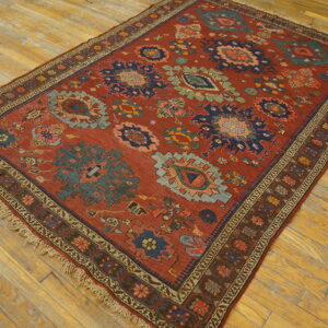 Geometric rust-toned rug featuring navy and sage medallions on a distressed wood floor.