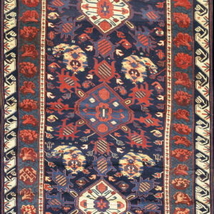 Navy blue runner rug featuring stepped central medallions and repeating red geometric floral border designs.