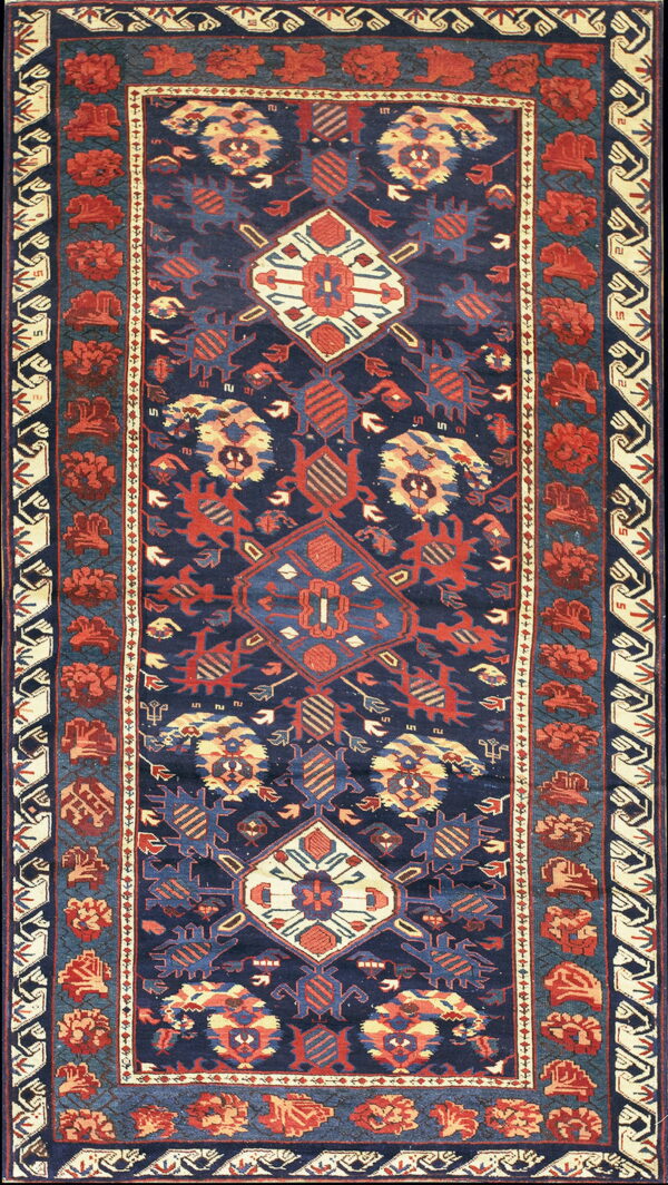 Navy blue runner rug featuring stepped central medallions and repeating red geometric floral border designs.