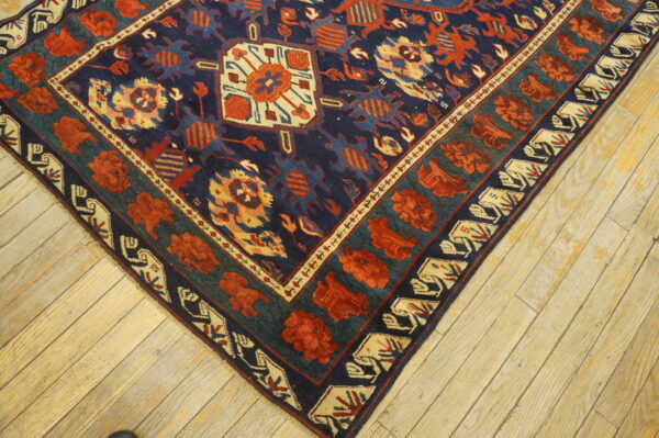 A high-pile rug with a navy, rust, teal, and cream geometric pattern lies on light wood floors.