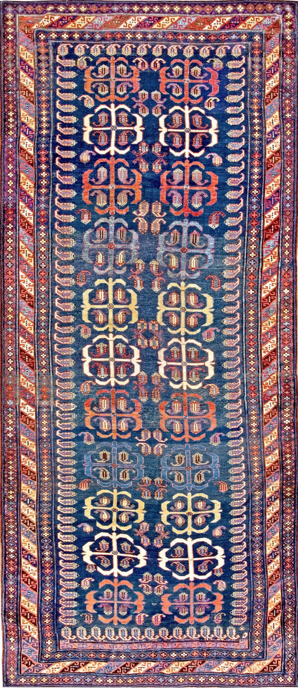 Navy blue runner rug featuring repeating geometric guls in rust, cream, and red tones.