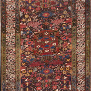 A long runner rug features a busy geometric tribal pattern in red, blue, green, and dark brown.