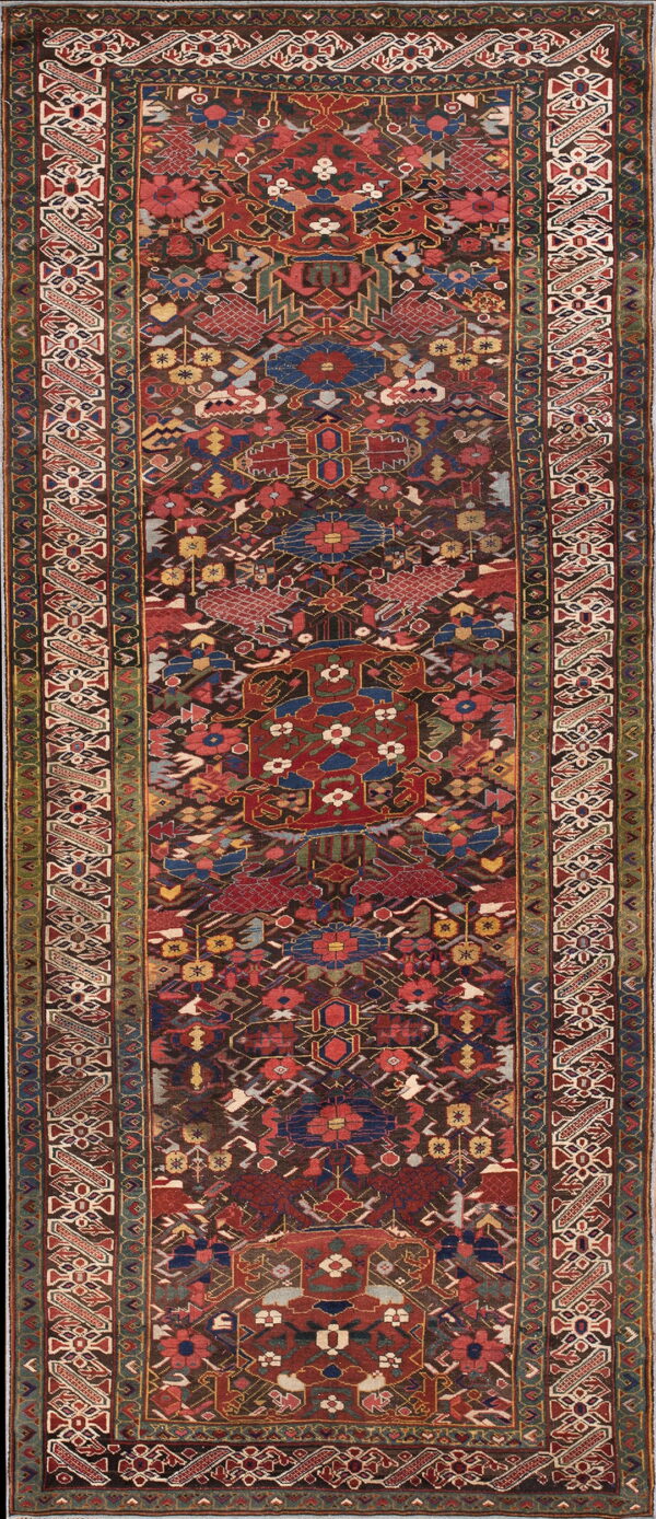 A long runner rug features a busy geometric tribal pattern in red, blue, green, and dark brown.