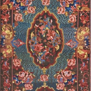A runner rug with ornate red, pink, and yellow floral medallions on a teal geometric field.