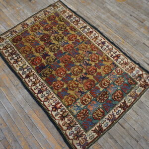 A rust, teal, and gold geometric pattern rug with a detailed cream border rests on weathered wood floors.
