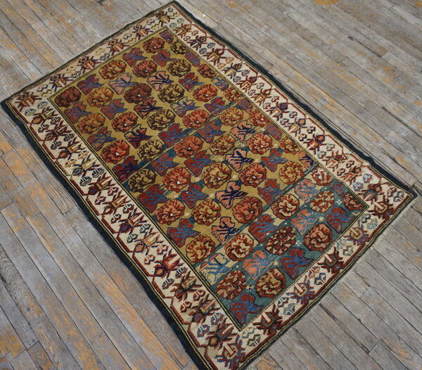 A rust, teal, and gold geometric pattern rug with a detailed cream border rests on weathered wood floors.