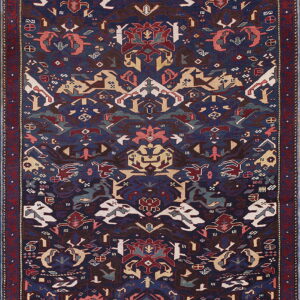 Navy blue rug with a symmetrical, stylized design featuring abstract animal motifs and a wide red border.
