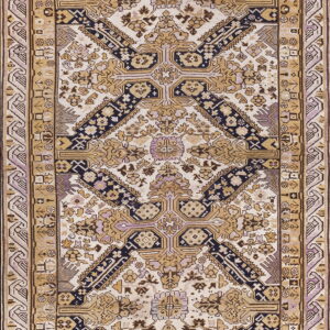 Detailed low-pile rug featuring geometric patterns in cream, khaki, navy, and muted purple tones.