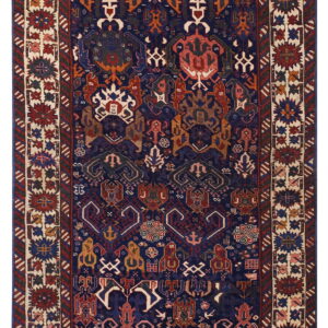 Dark blue rug with a complex, multi-colored tribal geometric pattern and wide ivory borders.