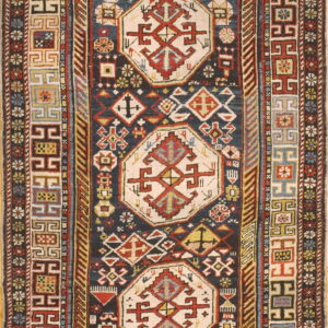Detailed, traditional rug with a dark field, three central light medallions, and intricate geometric borders.