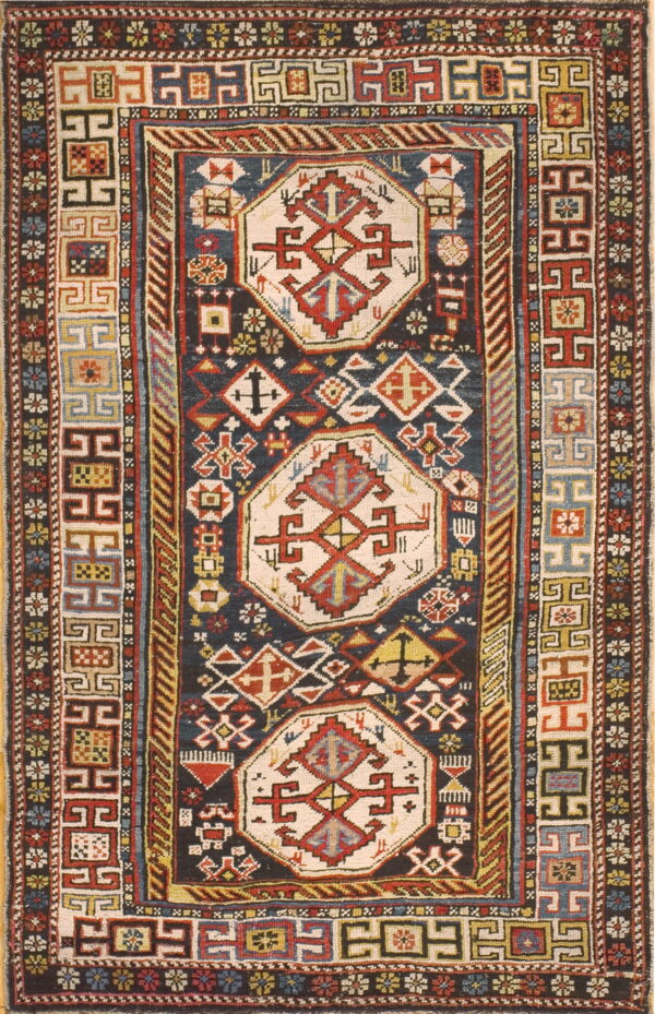 Detailed, traditional rug with a dark field, three central light medallions, and intricate geometric borders.