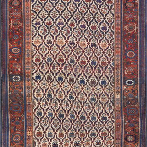 A patterned rug with a diamond navy and ivory field, framed by wide red and dark blue borders.