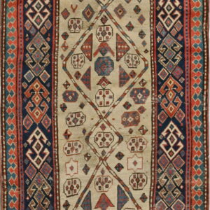 Runner rug featuring a cream field with geometric red and blue shapes enclosed by a dark blue patterned border.