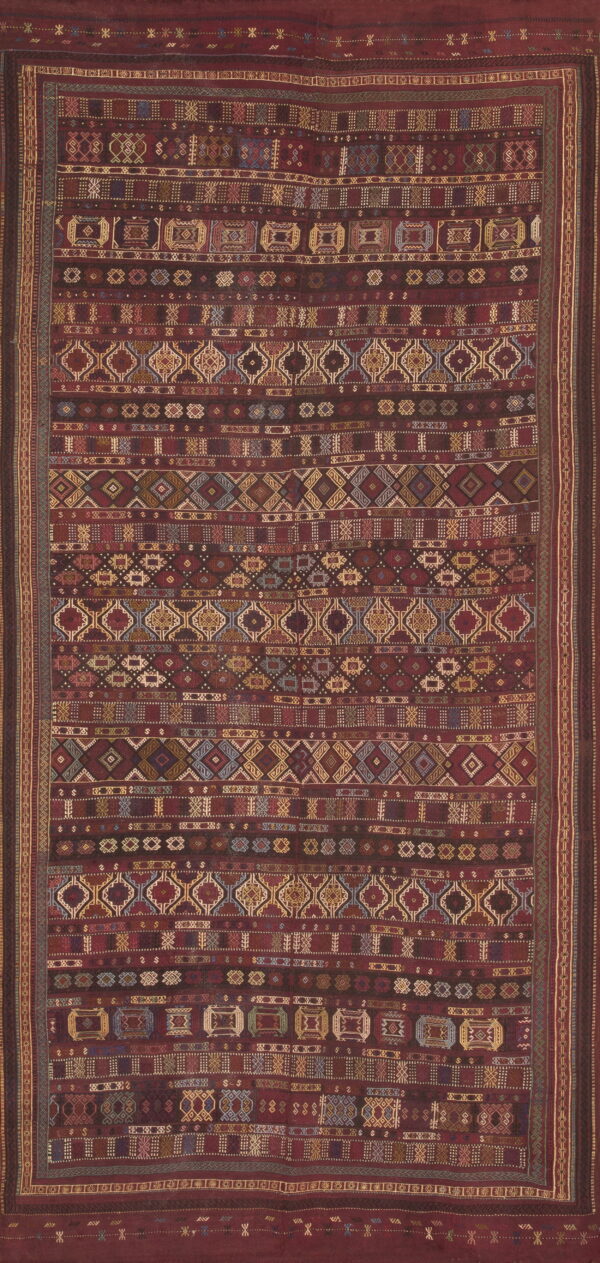 Burgundy flatwoven rug featuring horizontal bands of dense, multicolored geometric patterns and tribal motifs.
