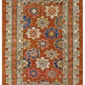 Rust colored rug with repeating blue, pink, and cream star motifs bordered by intricate geometric patterns.