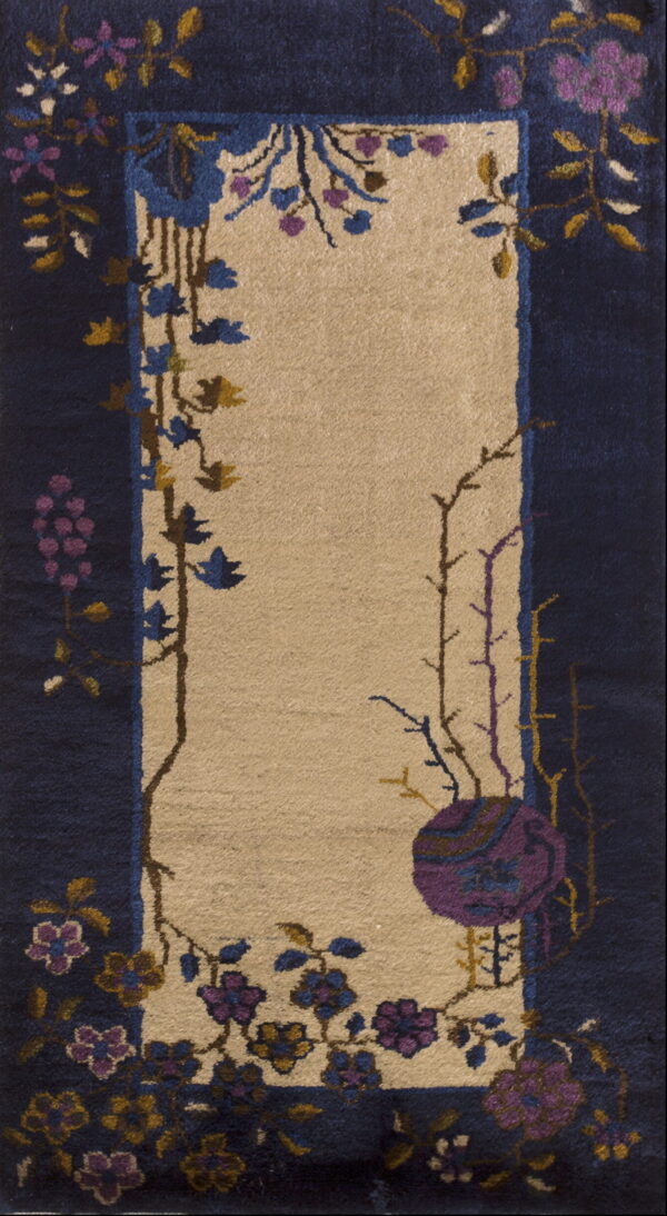 Beige center panel rug framed by navy blue with scattered blue and purple floral motifs.