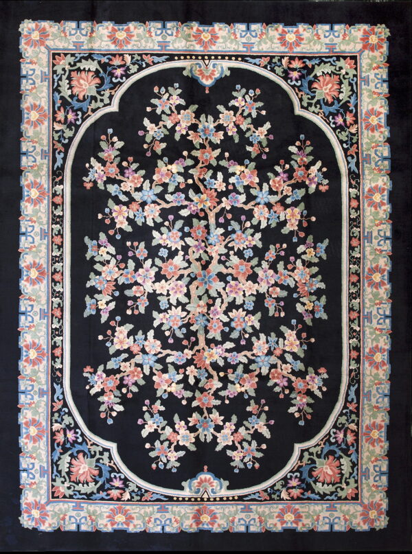 Black rug with a central multi-colored flowering tree pattern inside an arched frame and a pale floral border.