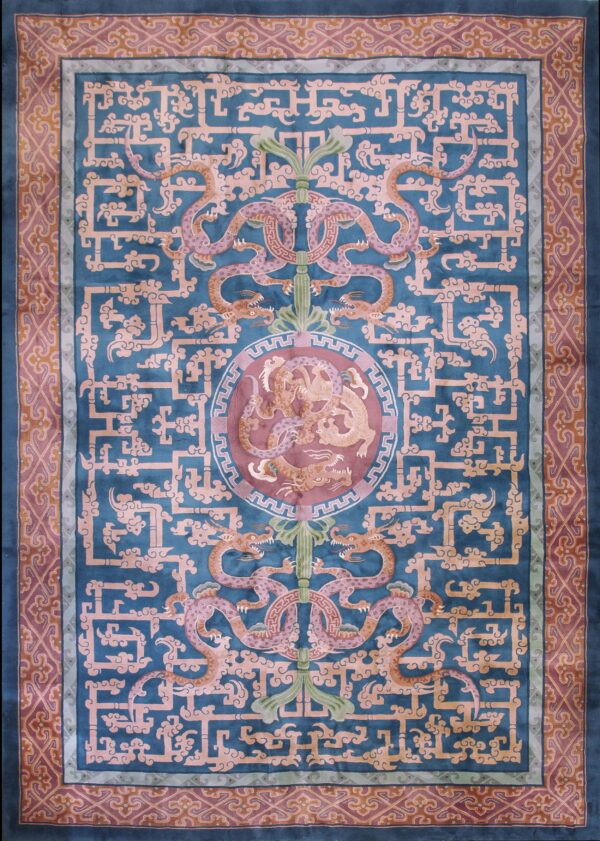 An intricate traditional rug in deep teal, salmon, and mauve with dragons and geometric fretwork.
