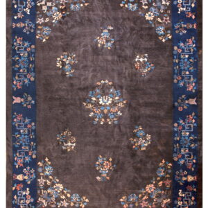 Dark charcoal rug with a thick navy border and scattered pink and blue floral vase motifs.