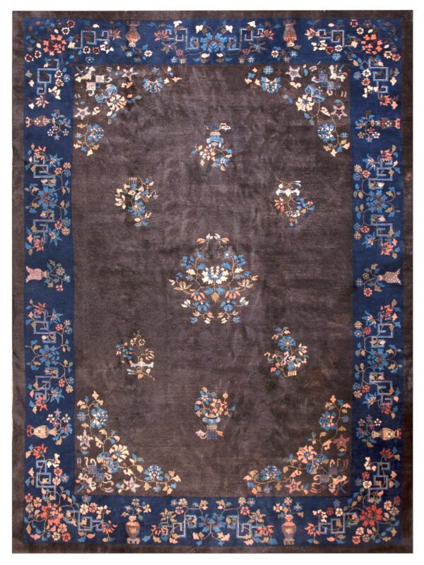 Dark charcoal rug with a thick navy border and scattered pink and blue floral vase motifs.