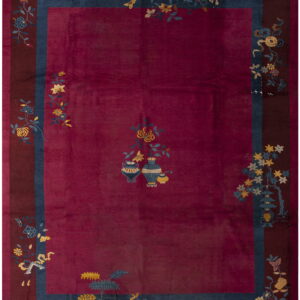 Deep magenta rug with a plush texture, maroon border, and scattered yellow and blue floral patterns.