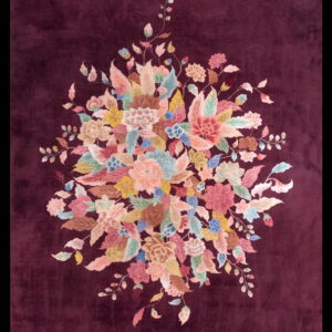 A deep plum rug centered with a vivid bouquet of pastel pink, blue, green, and yellow flowers.