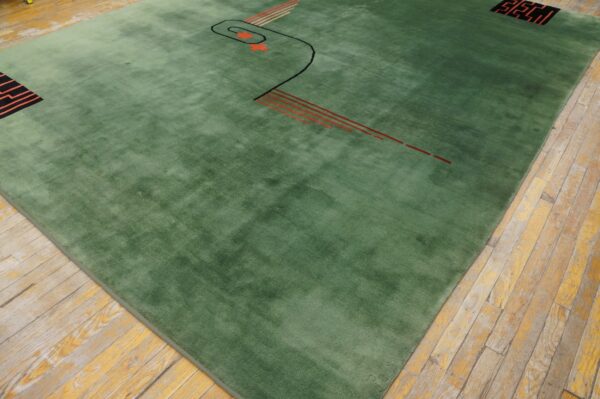 Green plush rug featuring abstract black and orange linear patterns on rustic hardwood floors.